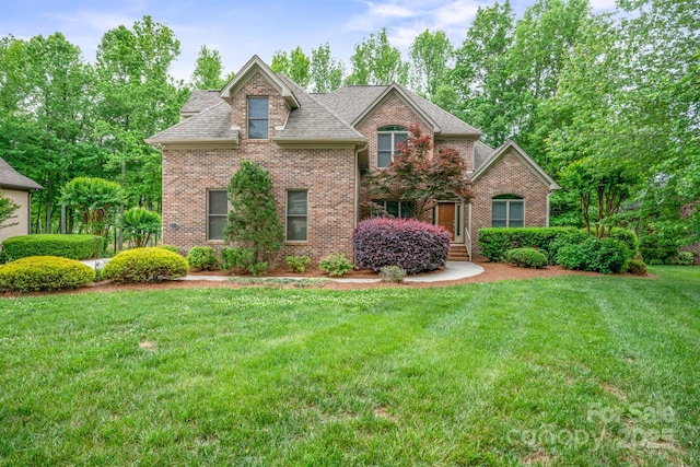 8216 Malibu Pointe Ln, Denver, NC 28037 - traditional-style house with brick siding, a front yard, and roof with shingles