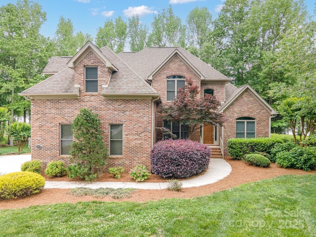 8216 Malibu Pointe Ln, Denver, NC 28037 - traditional home with brick siding, a shingled roof, and a front lawn