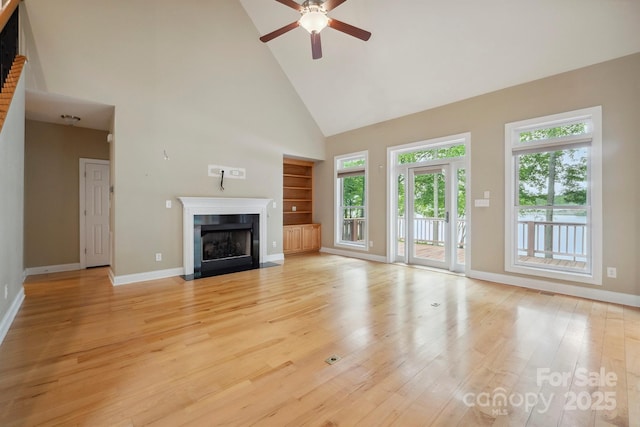 8216 Malibu Pointe Ln, Denver, NC 28037 - unfurnished living room featuring high vaulted ceiling, light wood-style flooring, ceiling fan, baseboards, and a fireplace with flush hearth