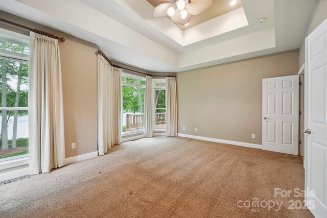 8216 Malibu Pointe Ln, Denver, NC 28037 - spare room with carpet floors, a tray ceiling, a ceiling fan, and baseboards