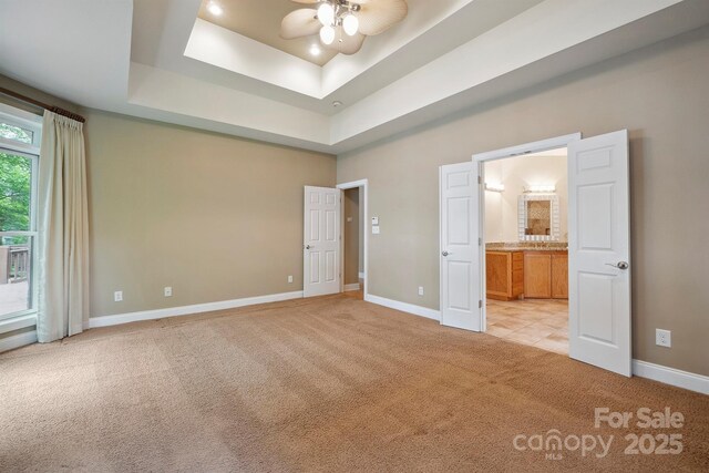 8216 Malibu Pointe Ln, Denver, NC 28037 - unfurnished bedroom featuring light carpet, baseboards, a tray ceiling, and ensuite bath