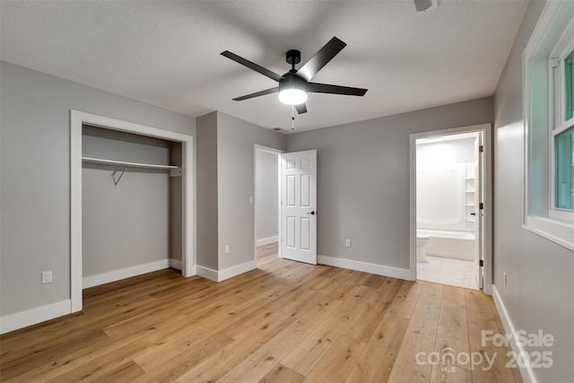16 Arkansas Trl, Cullowhee, NC 28723 - unfurnished bedroom featuring light wood-type flooring, baseboards, a closet, connected bathroom, and a ceiling fan
