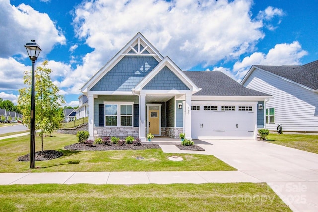 craftsman house with a garage, a front lawn, driveway, stone siding, and covered porch