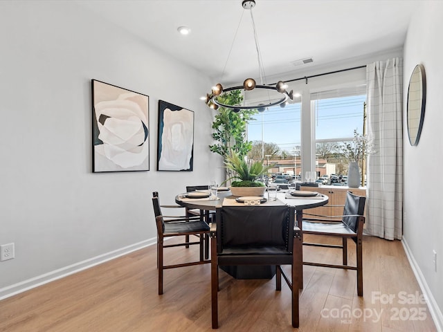 5517 Swaling St, Charlotte, NC 28217 - dining area with light wood-type flooring, baseboards, and a chandelier