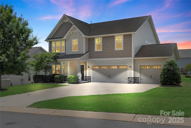3211 Gilroy Dr, Fort Mill, SC 29707 - craftsman-style home with driveway, a front lawn, an attached garage, and stone siding