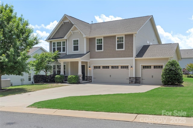3211 Gilroy Dr, Fort Mill, SC 29707 - craftsman-style house featuring a front lawn, driveway, stone siding, and a garage