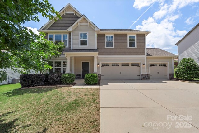 3211 Gilroy Dr, Fort Mill, SC 29707 - craftsman house featuring driveway, stone siding, a front lawn, a garage, and central air condition unit
