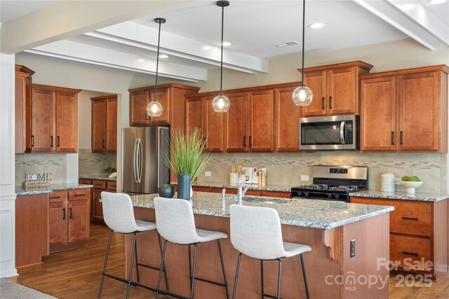 3211 Gilroy Dr, Fort Mill, SC 29707 - kitchen featuring appliances with stainless steel finishes, a sink, brown cabinets, backsplash, and a breakfast bar