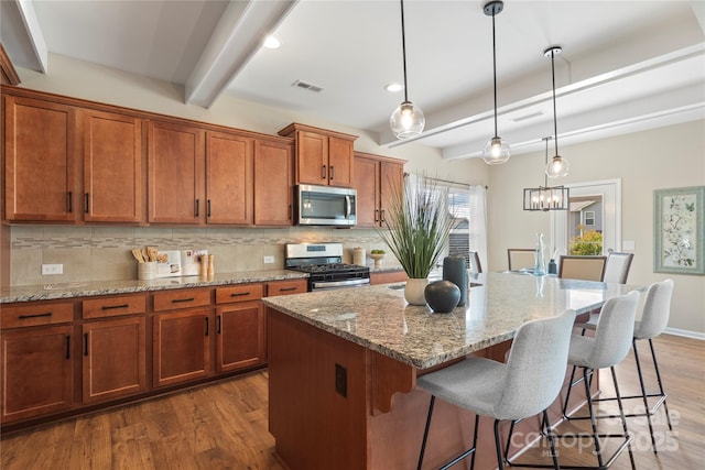 3211 Gilroy Dr, Fort Mill, SC 29707 - kitchen with stainless steel appliances, beamed ceiling, decorative backsplash, brown cabinets, and dark wood-type flooring