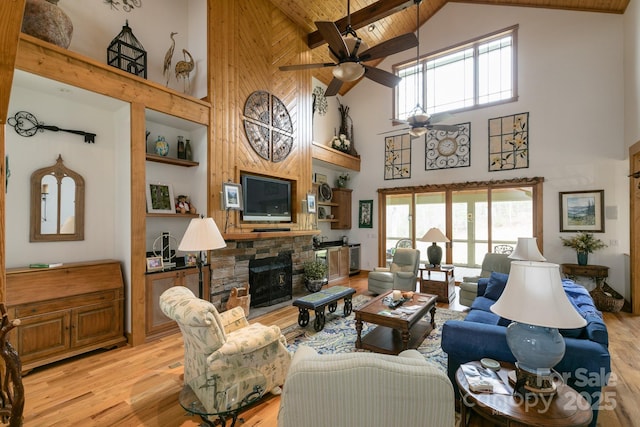 324 Austin Mountain Dr, Burnsville, NC 28714 - living area featuring high vaulted ceiling, a stone fireplace, light wood-style floors, ceiling fan, and wood ceiling