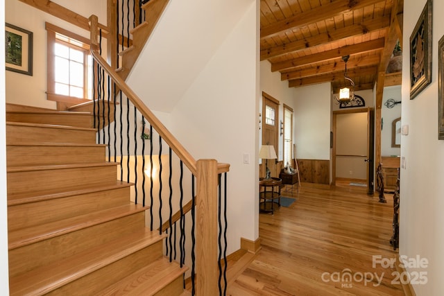 324 Austin Mountain Dr, Burnsville, NC 28714 - stairs featuring wooden ceiling, beam ceiling, healthy amount of natural light, wood finished floors, and wainscoting