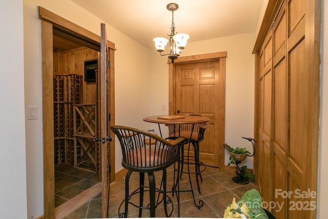 324 Austin Mountain Dr, Burnsville, NC 28714 - wine area with dark tile patterned flooring, a chandelier, and baseboards