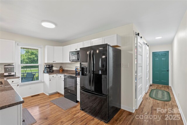 4916 Ritchie Rd, Lincolnton, NC 28092 - kitchen with black appliances, light wood-style flooring, white cabinetry, and baseboards