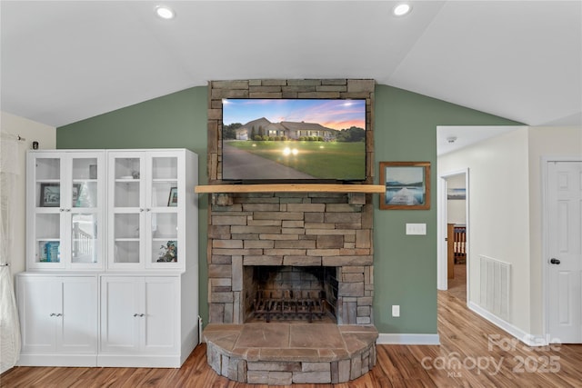 4916 Ritchie Rd, Lincolnton, NC 28092 - living area featuring lofted ceiling, wood finished floors, a stone fireplace, and baseboards