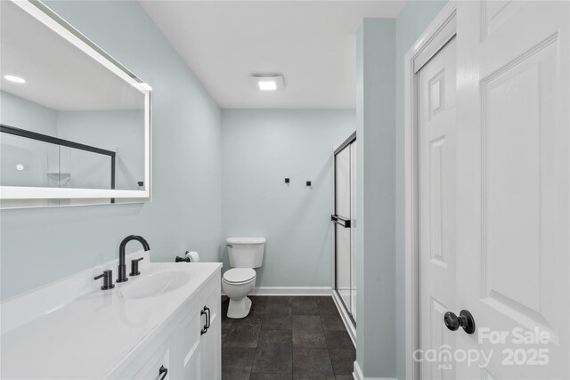 4916 Ritchie Rd, Lincolnton, NC 28092 - bathroom featuring toilet, a stall shower, vanity, baseboards, and stone finish floors