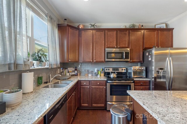 4313 Courtly Ln, Belmont, NC 28012 - kitchen featuring appliances with stainless steel finishes, a sink, light stone countertops, backsplash, and crown molding