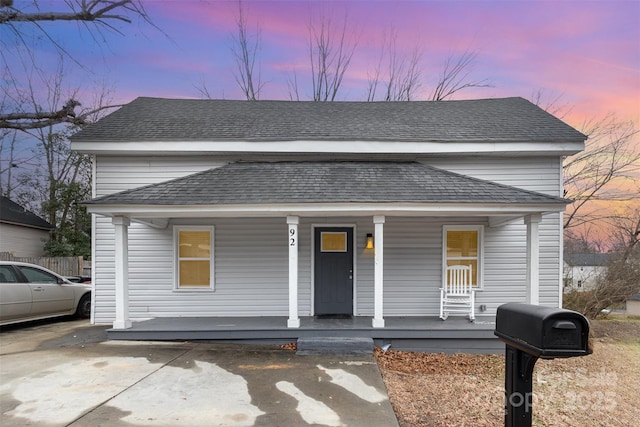 view of front of property with roof with shingles and a porch