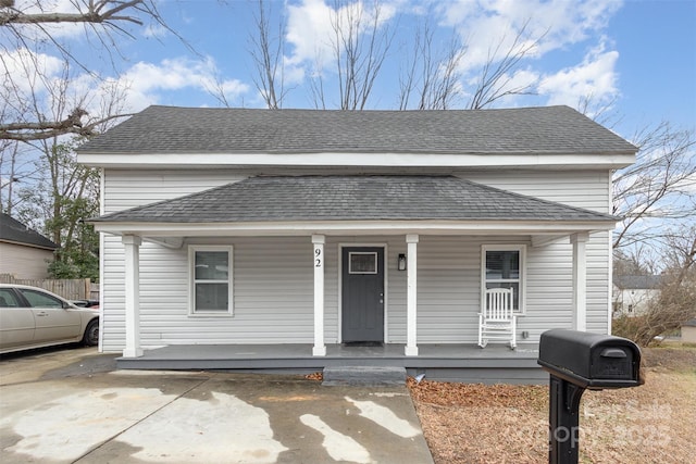 view of front of home with roof with shingles and covered porch