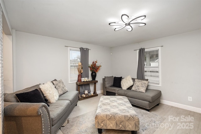 living room with baseboards and light wood-style floors
