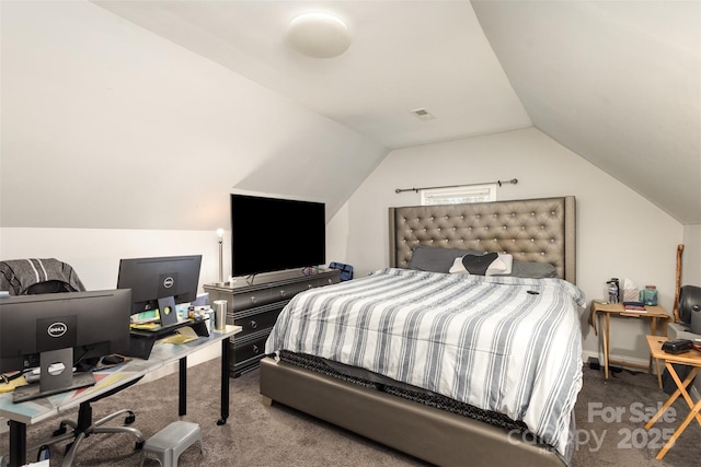 carpeted bedroom with vaulted ceiling and a desk