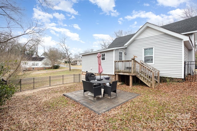 back of property featuring a shingled roof and a patio