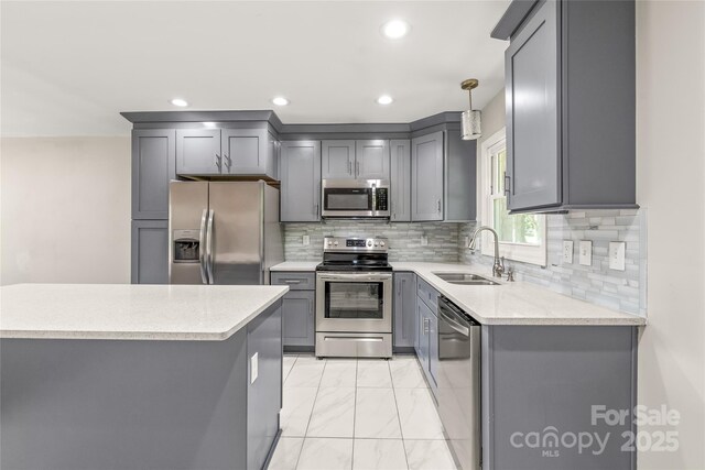 kitchen featuring a sink, appliances with stainless steel finishes, gray cabinetry, light marble finish flooring, and recessed lighting