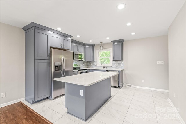 kitchen featuring appliances with stainless steel finishes, baseboards, gray cabinetry, and recessed lighting