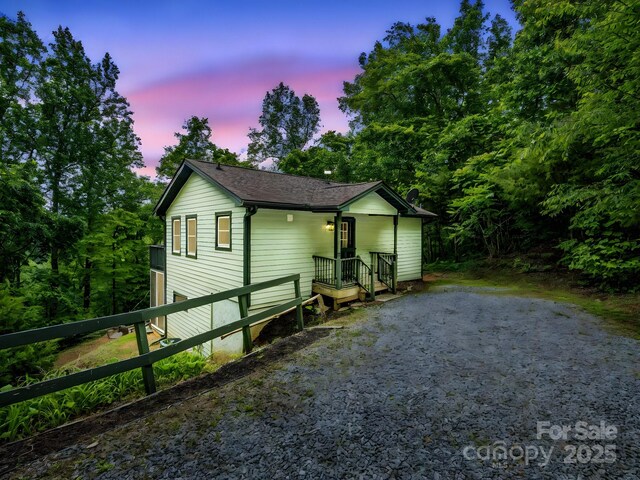 view of front of home featuring roof with shingles and driveway