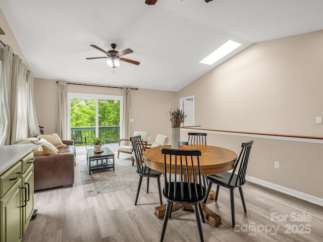 dining space featuring a ceiling fan, light wood-type flooring, vaulted ceiling, and baseboards