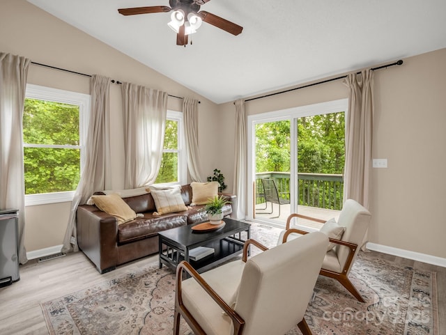 living room with vaulted ceiling, ceiling fan, baseboards, and light wood finished floors