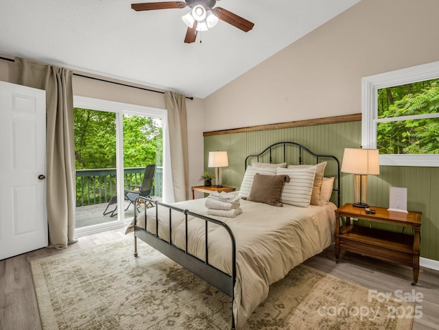 bedroom with access to outside, vaulted ceiling, wood finished floors, and ceiling fan