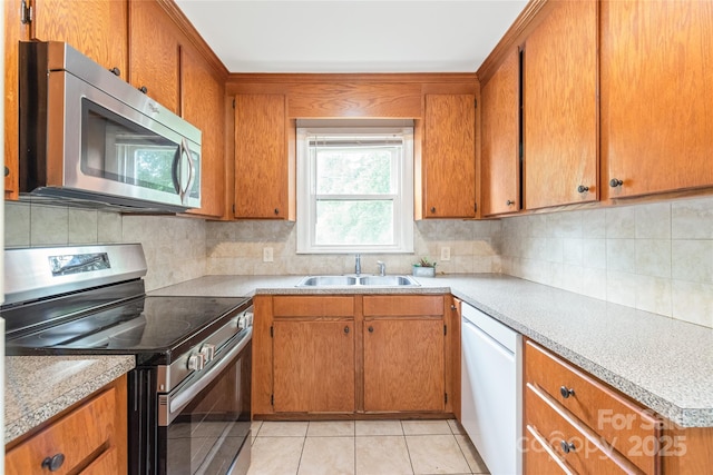 104 Willetta Dr, Charlotte, NC 28217 - kitchen with stainless steel appliances, a sink, tasteful backsplash, and brown cabinets