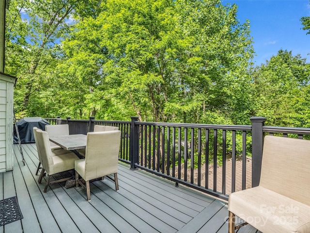 wooden deck featuring outdoor dining area and a grill