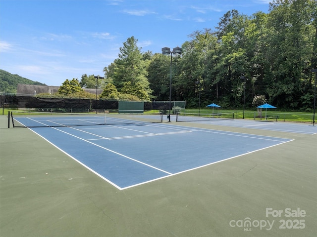 view of tennis court with fence and community basketball court