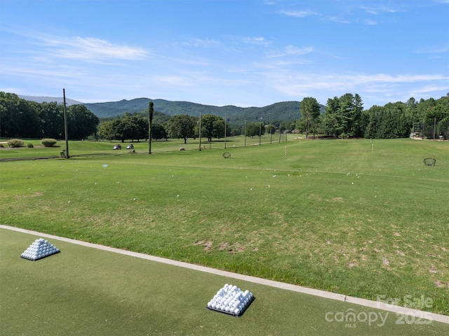 view of home's community with a mountain view and a lawn