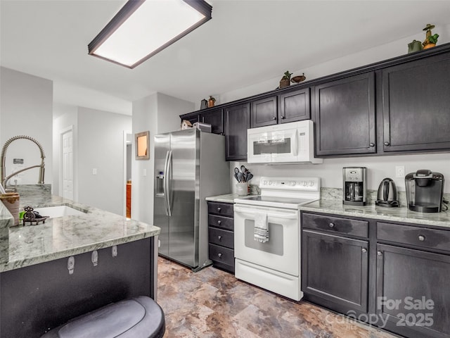 kitchen with white appliances, a sink, light stone countertops, and stone finish flooring
