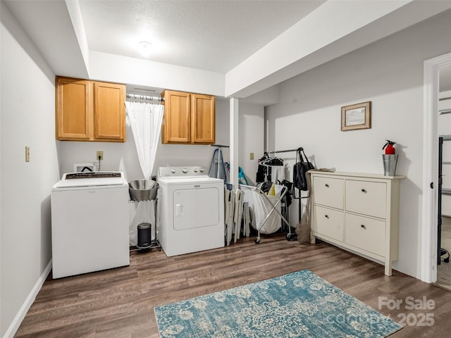 laundry area with cabinet space, washing machine and dryer, wood finished floors, and a textured ceiling