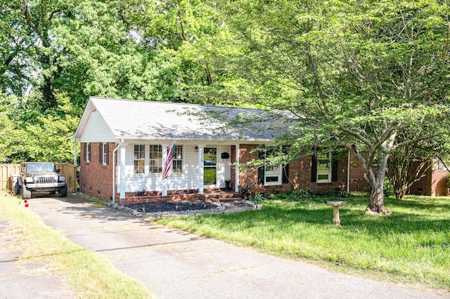 1115 Grovewood Dr, Charlotte, NC 28208 - view of front of property featuring brick siding, asphalt driveway, a front yard, covered porch, and crawl space