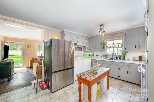 1115 Grovewood Dr, Charlotte, NC 28208 - kitchen featuring freestanding refrigerator, washing machine and clothes dryer, ornamental molding, a sink, and plenty of natural light