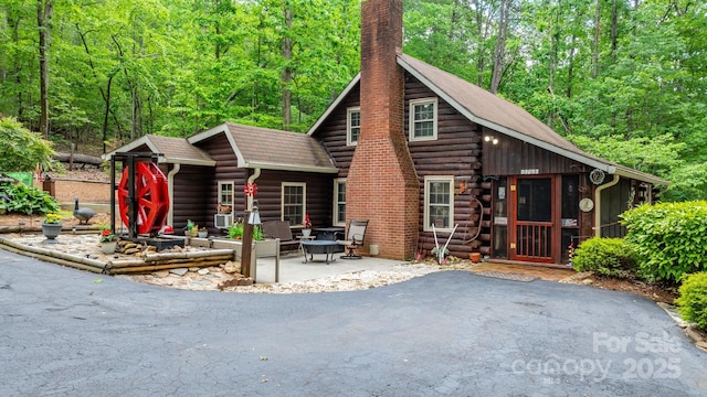 3763 Laurel Heights Dr, Morganton, NC 28655 - log-style house with a chimney, a patio, log exterior, and a view of trees