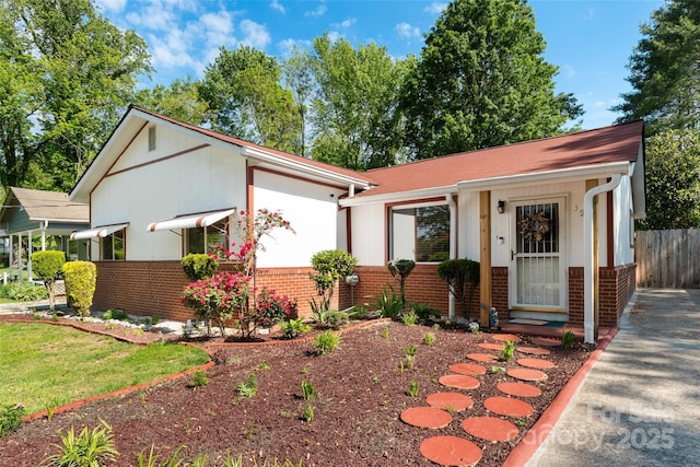 view of front of house featuring brick siding and fence