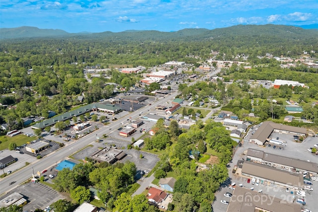 aerial view of property and surrounding area featuring mountains and a forest