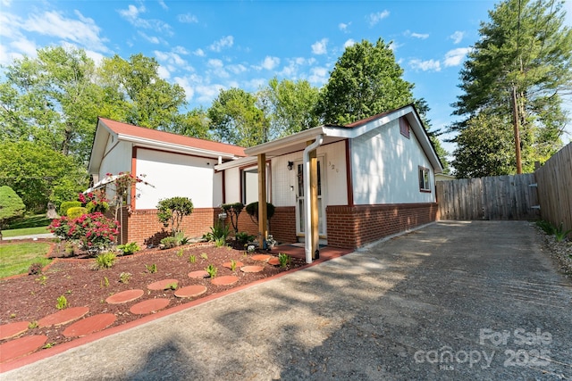view of front of property featuring brick siding and fence