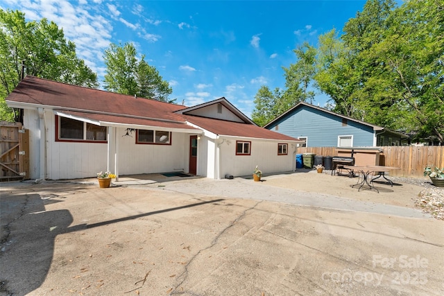rear view of house featuring fence and a patio
