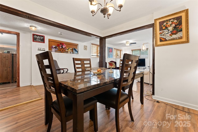 dining room with a chandelier, light wood-style flooring, and baseboards