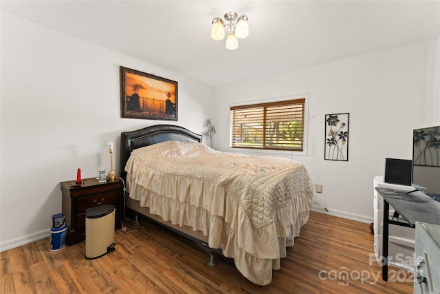 bedroom featuring wood finished floors and baseboards