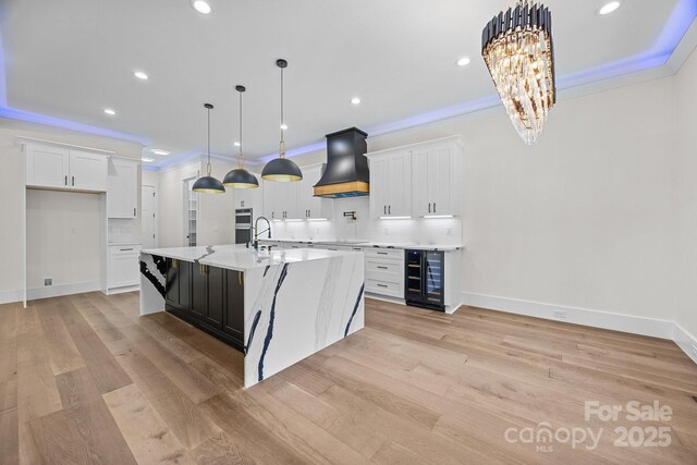 1408 Bloomsberry Ln, Waxhaw, NC 28173 - kitchen with custom range hood, wine cooler, light countertops, white cabinets, and recessed lighting