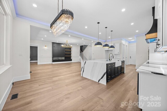 1408 Bloomsberry Ln, Waxhaw, NC 28173 - kitchen featuring a chandelier, ornamental molding, light wood-style floors, a tray ceiling, and white cabinets