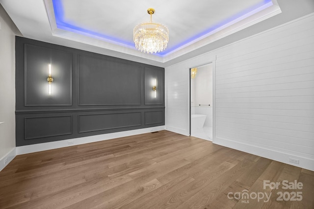 1408 Bloomsberry Ln, Waxhaw, NC 28173 - spare room with a raised ceiling, a chandelier, wood finished floors, and baseboards