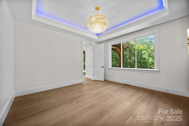 1408 Bloomsberry Ln, Waxhaw, NC 28173 - spare room featuring a tray ceiling, a chandelier, and wood finished floors
